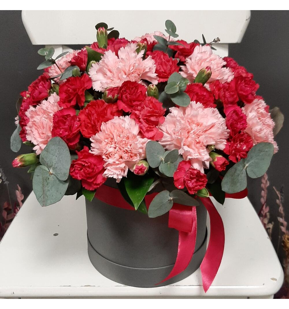 Яркая кустовая и нежно коралловая гвоздика в шляпной коробке